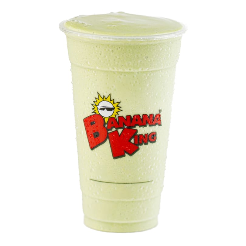 A Banana King green smoothie in a clear plastic cup with condensation, against a white background.