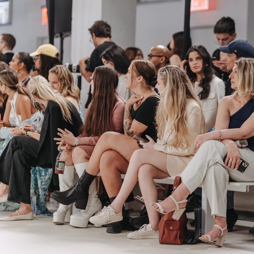 A diverse group of people, mostly women, seated and observing an event.