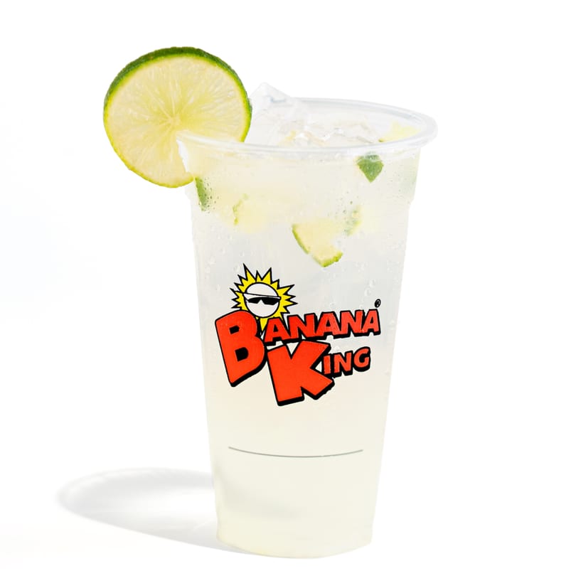 Banana King's refreshing lime drink with ice and lime slices in a clear cup.
