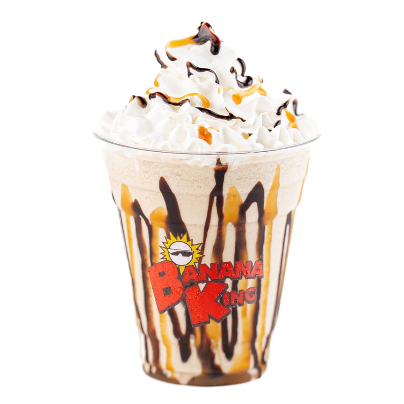 Banana King milkshake with whipped cream, chocolate, and caramel drizzle in a branded cup.