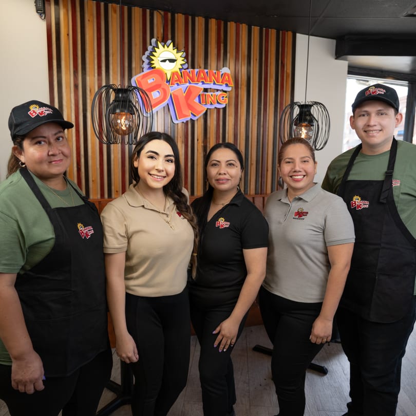 Five Banana King restaurant staff members, three women and two men, smiling in uniform.