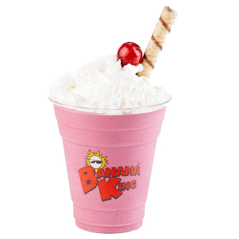 Pink Banana King milkshake with whipped cream, a cherry, and a wafer stick.